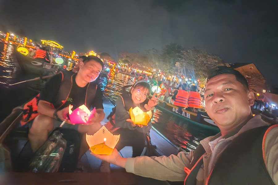 Mr. Viet Nguyen with guests on a lantern boat ride in Hoi An during a Central Vietnam holiday package
