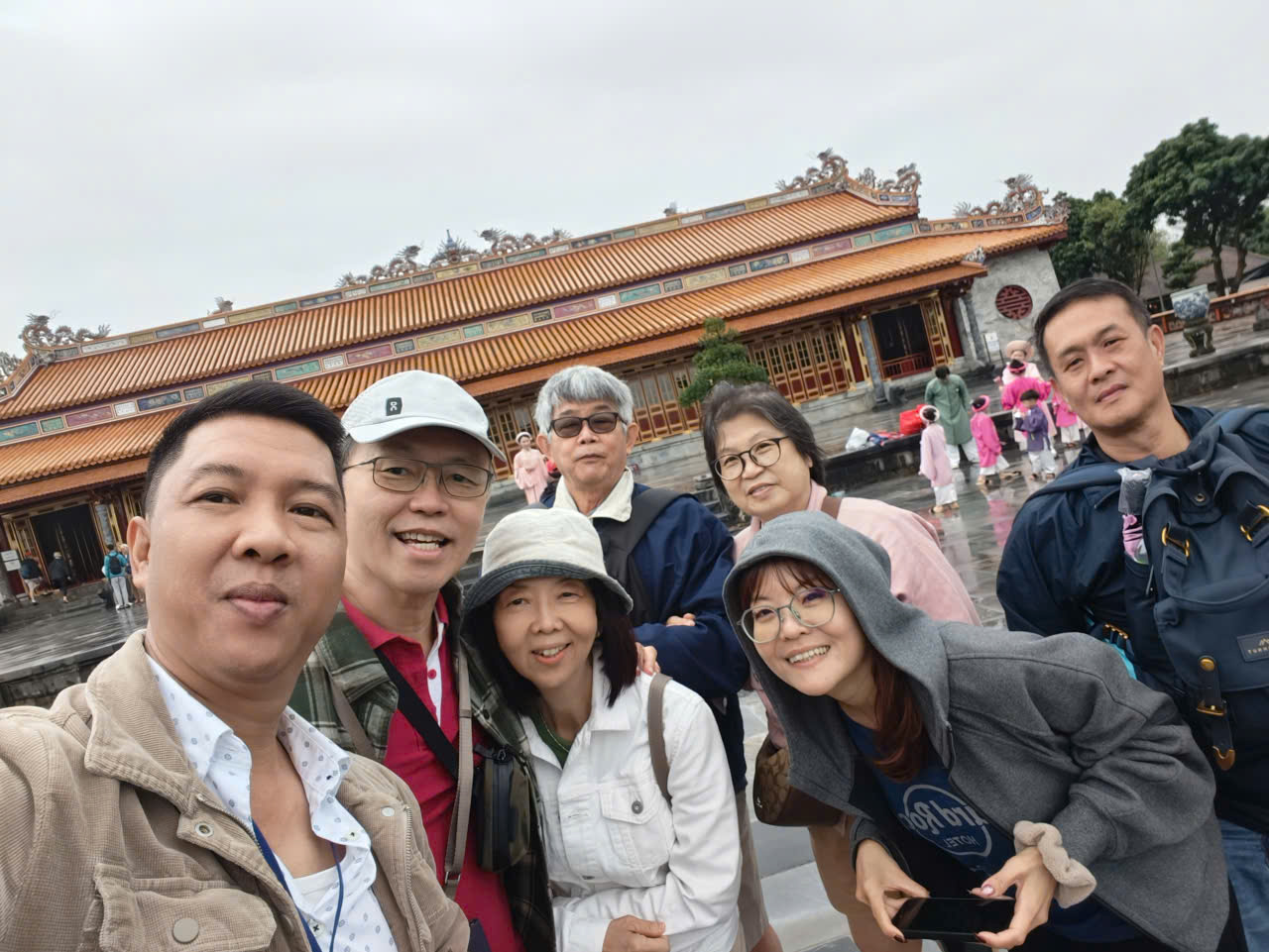 Viet Nguyen taking a selfie with guests in front of Thai Hoa Palace at Hue Imperial City