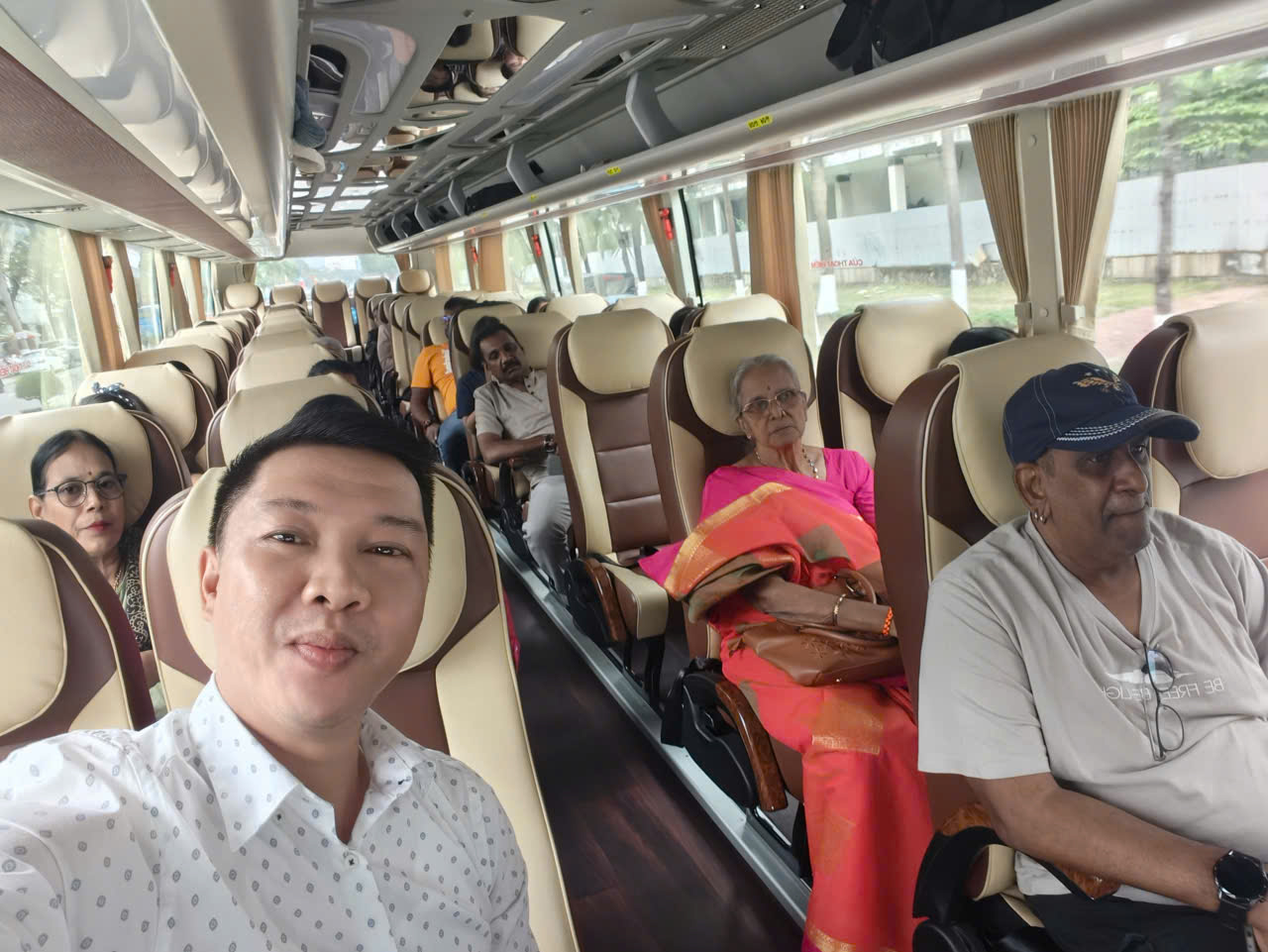Viet Nguyen taking a selfie with guests on the bus during a Hue Imperial City private tour from Da Nang.