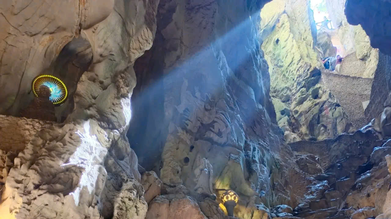 Sunlight streaming through the cave ceiling at Huyen Khong Cave in the Marble Mountains, Da Nang, Vietnam.