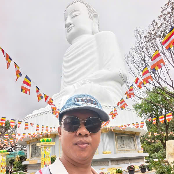 Viet Nguyen at the 28-meter Buddha statue of Linh Ung Pagoda in Ba Na Hills