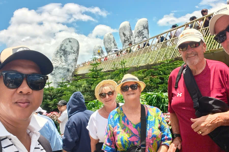 Tourists enjoying a photo together on the Golden Bridge at Ba Na Hills